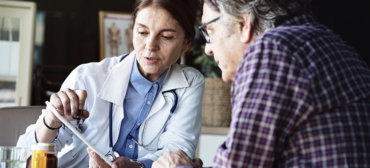 Médica hablando con un paciente​​ 